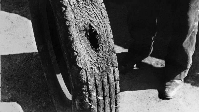 Black and white close up of a badly worn damaged tire tread